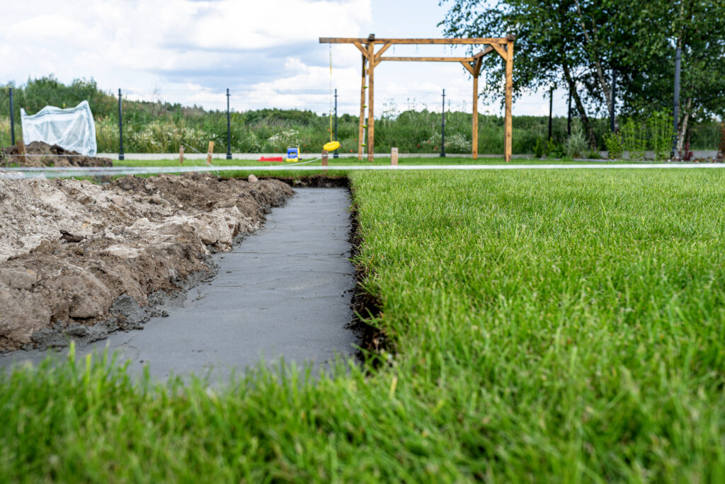 Foundation footings poured in a ditch in the yard, building a terrace in the backyard.